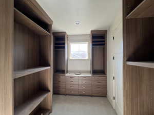 Walk in closet featuring light colored carpet