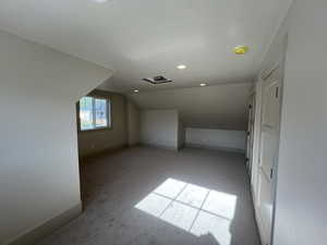 Bonus room featuring vaulted ceiling, light carpet, baseboards, and recessed lighting