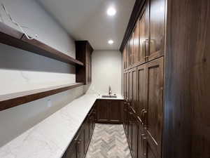 Indoor wet bar with brick patterned floors and recessed lighting