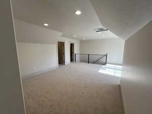 Bonus room with light colored carpet, recessed lighting, a textured ceiling, and baseboards
