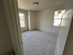Empty room featuring light colored carpet, plenty of natural light, baseboards, and recessed lighting