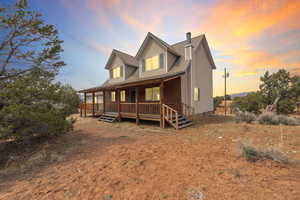 Rear view of property featuring a porch and metal roof