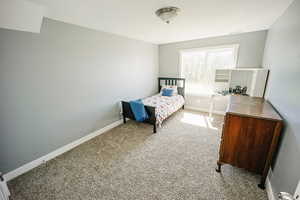 Bedroom with carpet floors, visible vents, and baseboards