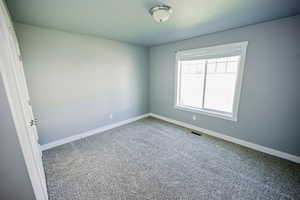 Unfurnished room with carpet, visible vents, and baseboards