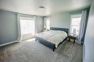 Carpeted bedroom featuring baseboards