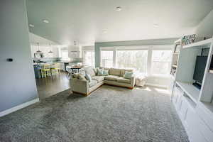 Living room with recessed lighting, dark colored carpet, and baseboards
