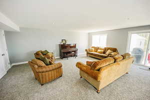 Living room featuring light colored carpet, baseboards, and recessed lighting