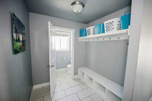 Mudroom with tile patterned flooring and baseboards