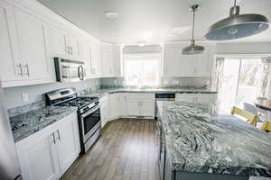 Kitchen featuring white cabinets, plenty of natural light, stainless steel appliances, and a sink