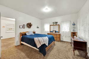 Bedroom featuring light carpet and baseboards