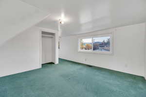 Additional living space featuring visible vents and carpet