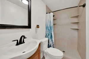 Updated bathroom featuring toilet, a tile shower, and vanity