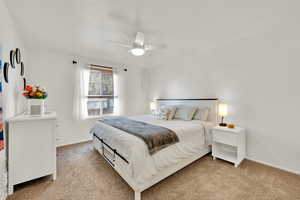 Bedroom with baseboards, ceiling fan, and light colored carpet. Has a door to the bathroom.