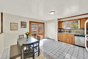 Kitchen featuring wood cabinets, light tile floors, large seating area, and white appliances