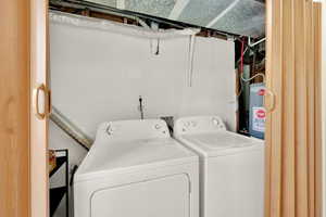 Laundry area featuring water heater, washing machine and dryer, and laundry area