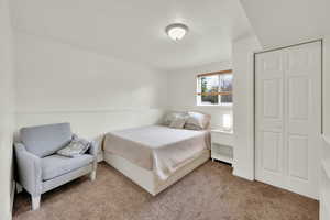 Bedroom with a closet and light colored carpet