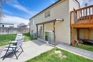 Rear view of house featuring a yard, a patio, central AC, and fence. Separate basement entrance.