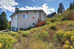 View of house featuring a deck, stairs, a 2-car garage