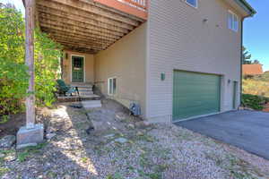 View of property exterior with a 2-car garage, asphalt driveway, and plenty of parking
