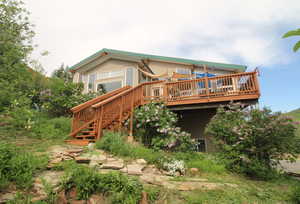 Back of property with stairway and a deck