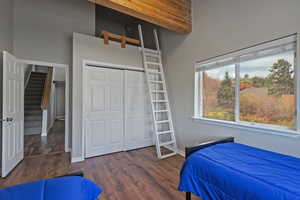 Bedroom with multiple windows, baseboards, and wood finished floors