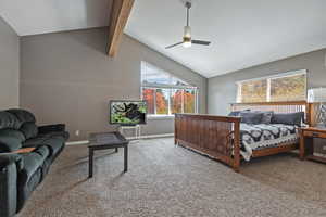 Carpeted bedroom featuring high vaulted ceiling, beamed ceiling, baseboards, and a ceiling fan