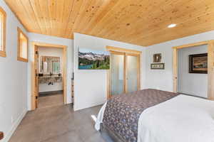 Bedroom featuring baseboards, a closet, tile patterned flooring, and wood ceiling