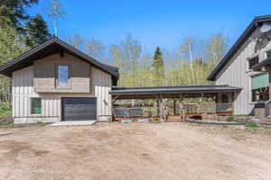 View of home's exterior featuring driveway, a carport, metal roof, and a garage