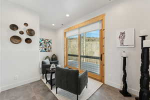 Living area with tile patterned floors, baseboards, and recessed lighting