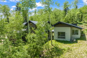 Exterior space with a standing seam roof, central AC unit, a yard, and metal roof