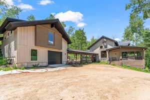 View of side of property featuring dirt driveway and an attached garage