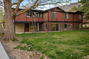 Rear view of property with a yard, brick siding, and a patio area