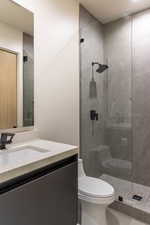 Bathroom with toilet, vanity, tile patterned floors, and a stall shower