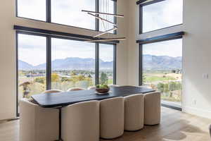 Dining room with seating for 10, light wood-style flooring, baseboards, and a mountain view