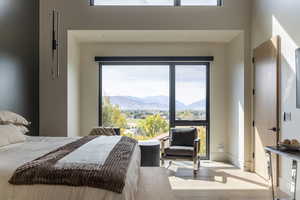 Primary Bedroom featuring wood finished floors, a mountain view, and multiple windows
