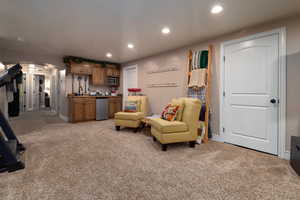 Living area featuring light colored carpet, recessed lighting, arched walkways, and bar area
