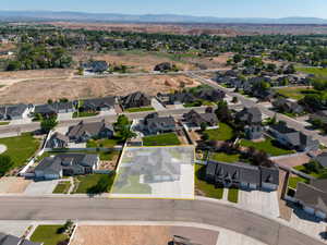 Aerial view of property and surrounding area with a mountainous background, nearby suburban area, and property boundaries highlighted