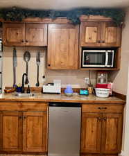 Interior space featuring a sink, stainless steel microwave, and dishwasher