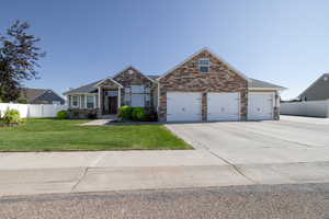 Craftsman-style home featuring stone siding, driveway, and a garage