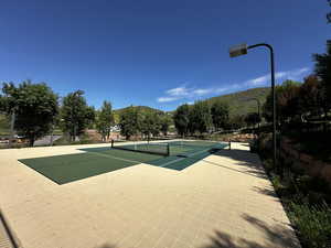 View of sport court with a mountain view and fence
