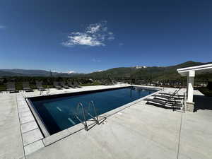 Community pool featuring a patio and a mountain view