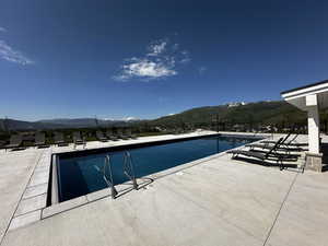 Community pool with a mountain view and a patio area
