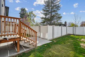 View of yard with a fenced backyard, stairs, and a patio