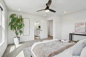 Bedroom featuring recessed lighting, a ceiling fan, light carpet, ensuite bath, and baseboards