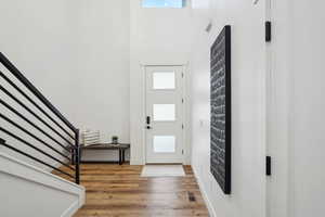 Foyer entrance with visible vents, stairs, and a wealth of natural light