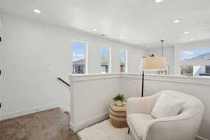 Sitting room featuring recessed lighting, an upstairs landing, and a healthy amount of sunlight