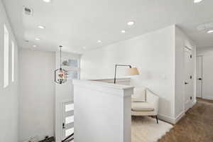 Hall with carpet floors, baseboards, recessed lighting, and a notable chandelier