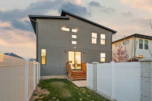 Rear view of property featuring fence private yard and stucco siding