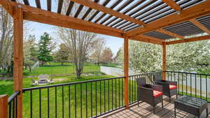 Covered deck overlooking the backyard with firepit, RV parking (not shown) and mature trees and garden area.