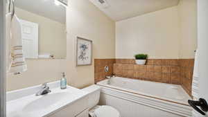 Full bathroom featuring visible vents, a garden tub, vanity.
